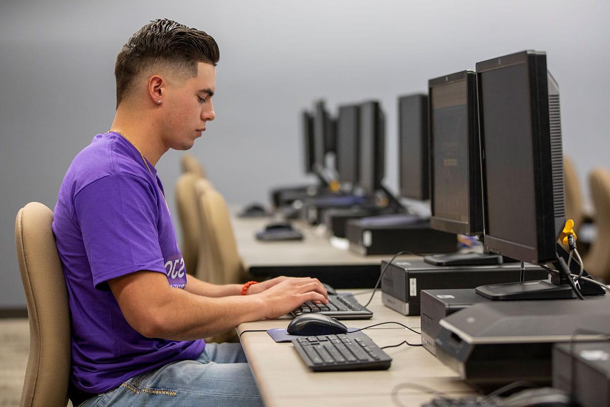 A San Juan College student using a computer in an on-campus computer lab